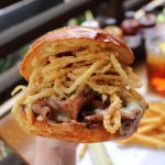 A burger with tiny fried onions at Gus's BBQ restaurant in Claremont