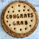 A pie with the words Congrats Grad on top of the pie crust.