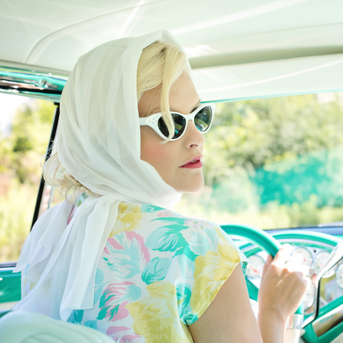 woman in car with scarf on head going on an epic road trip.